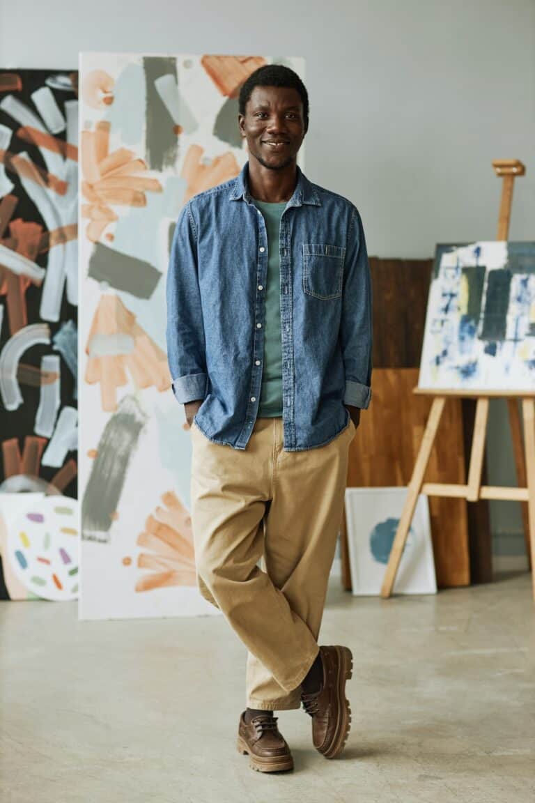 Happy young creative craftsman in casual attire standing in front of camera