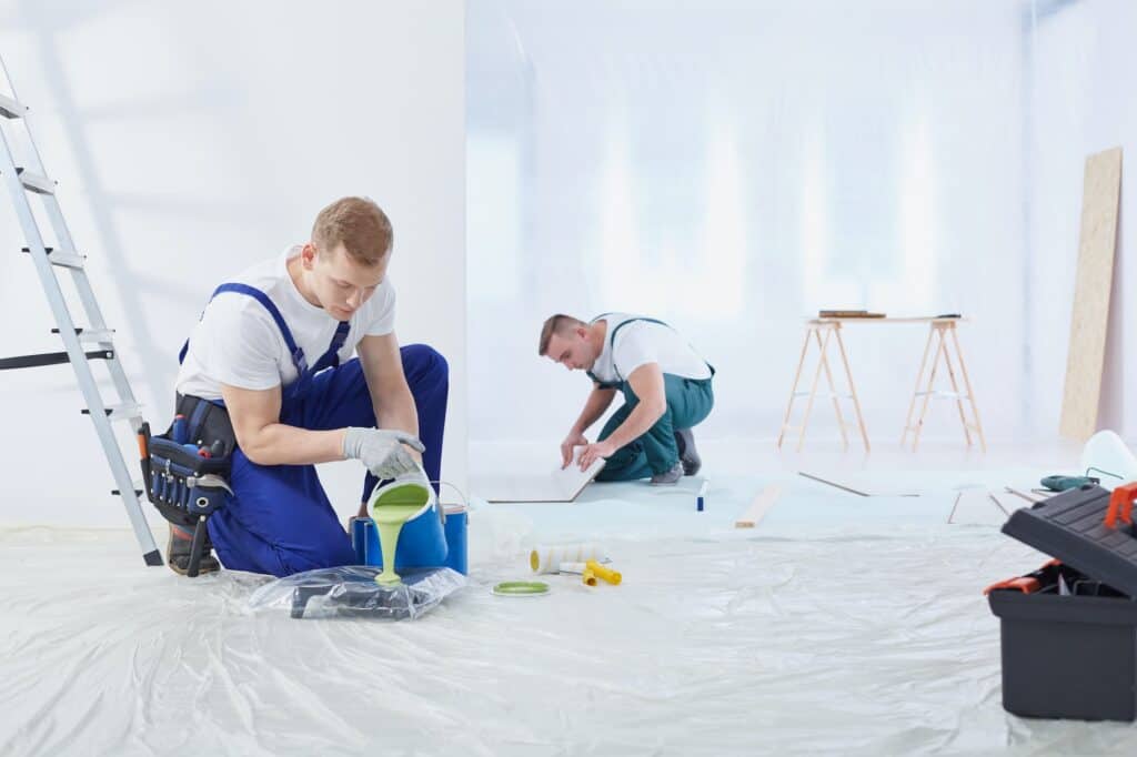 Two painters painting the wall